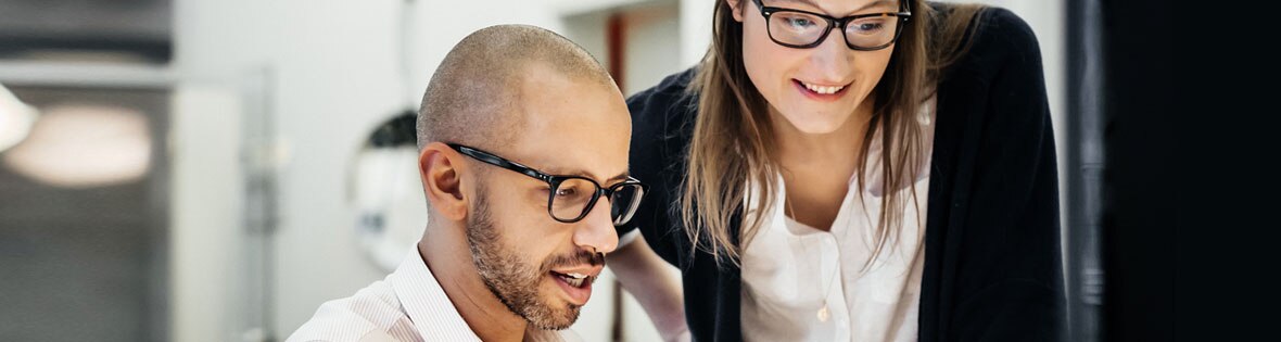 Foto de dos
							profesionales conversando en la oficina, que ilustra el artículo de Oracle NetSuite sobre
							las características de un ERP